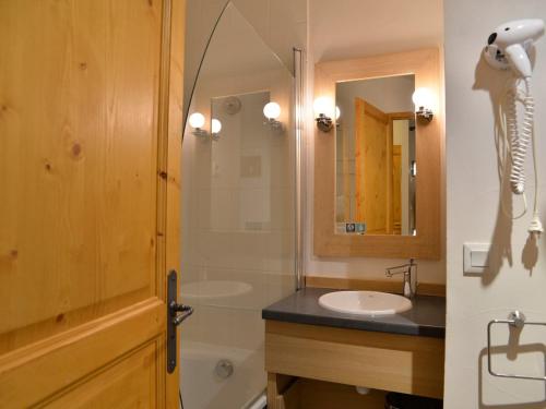 La salle de bains est pourvue de 2 lavabos, d'une douche et d'un miroir. dans l'établissement Appartement duplex 6 pers · Ski aux pieds · Piscine chauffée · Animaux admis - FR-1-181-2805, à La Plagne Tarentaise