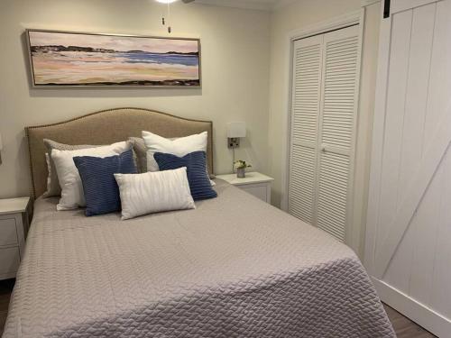 a bedroom with a bed with blue and white pillows at Shore To Please! Elegant couples retreat with bikes in Hilton Head Island