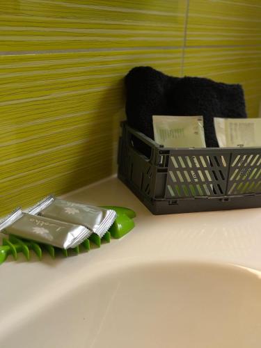 a bathroom sink with a basket of soap and towels at Hotel Ristorante della posta , cama in Cama