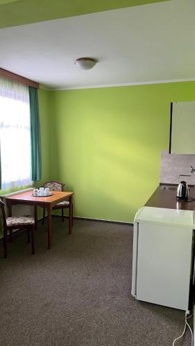 a room with a table and a green wall at Grandhotel Nový Bor in Nový Bor