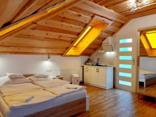 1 dormitorio con 2 camas en una habitación con techos de madera en Apartamenty przy szlaku, en Krajno Pierwsze