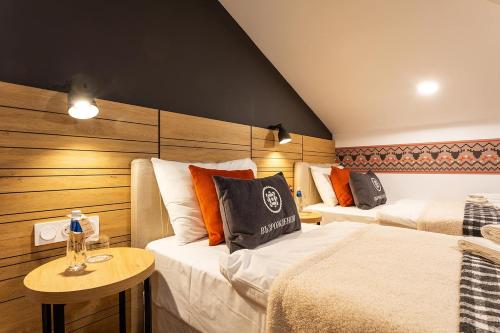 a room with two beds and a table in it at Complex Vazrozhdentsi in Tryavna