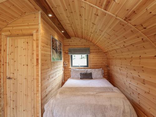 ロッカビーにあるCleugh Lodgeの木製の部屋にベッド付きの小さなベッドルーム1室