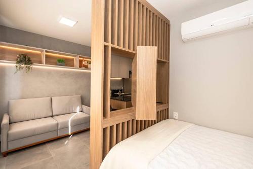 a bedroom with a bed and a couch in a room at Loft Moderno novo JPRE718 in Porto Alegre