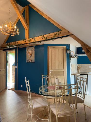 une salle à manger avec des murs bleus et une table en verre dans l'établissement Le Relais, La Dormance, Le Bois Dormant, à Châteauvieux