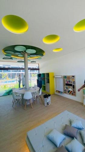 a room with a couch and a table and yellow lights at Flat Porto de Galinhas-Muro Alto Makia Beach in Ipojuca