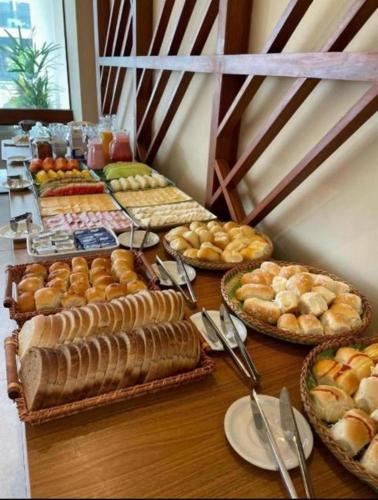 a table with many different types of bread and pastries at Flat Porto de Galinhas-Muro Alto Makia Beach in Ipojuca