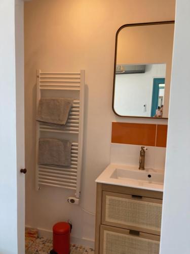 y baño con lavabo y espejo. en Les chambres du Phare en Le Port-des-Barques