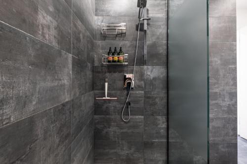 a bathroom with a shower with a phone at Les Eaux 233-2-Alpine Family Escape in Mont-Tremblant