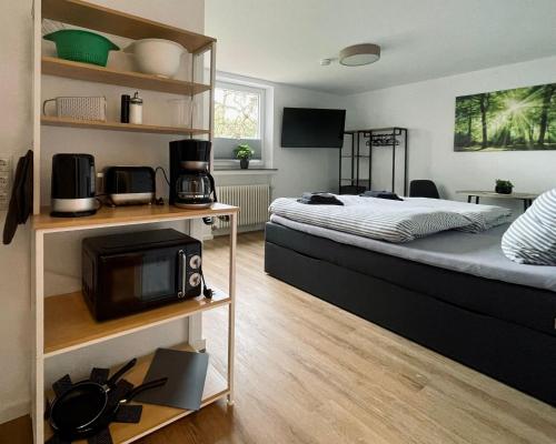 a bedroom with a bed with a microwave and a tv at Ferienwohnungen am Park in Wilhelmshaven