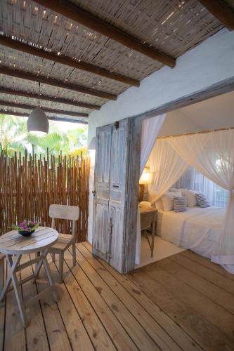 an open door in a bedroom with a bed and a table at Santa Fe Casas Hotel Trancoso in Trancoso
