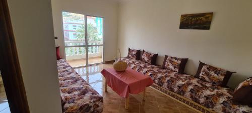 uma sala de estar com sofás, uma mesa e uma janela em Page et montagne chez Ben&Edd em Alcácer-Ceguer