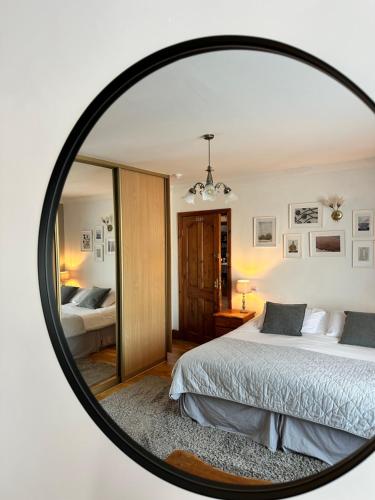a mirror reflecting a bedroom with a bed in it at Malahide Guest Rooms in Malahide