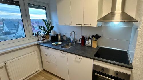 a kitchen with white cabinets and a sink and a window at MiCasa TuСasa - 2-R-Apartment Leipziger Neuseenland Hydra in Borna