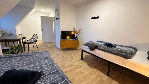 a room with a bed and a table and a tv at MiCasa TuСasa - 2-R-Apartment Leipziger Neuseenland Hydra in Borna