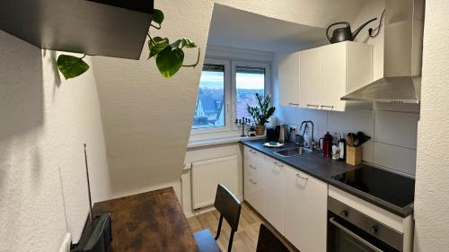 a kitchen with white cabinets and a table and a window at MiCasa TuСasa - 2-R-Apartment Leipziger Neuseenland Hydra in Borna