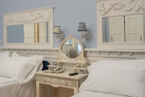 a white bedroom with a mirror and a bed at Villa Vicuña Hotel Boutique in Salta