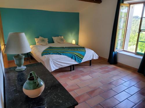 a bedroom with a bed and a lamp on a table at La Magnanerie du Berguier in Laurac-en-Vivarais