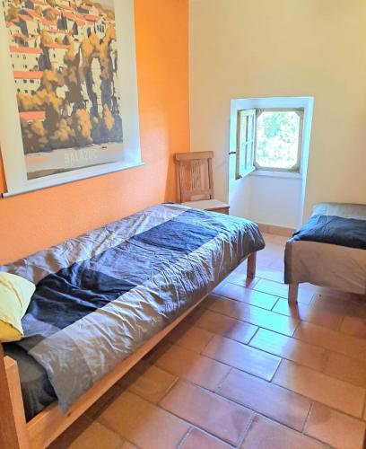 a bedroom with a bed and a painting on the wall at La Magnanerie du Berguier in Laurac-en-Vivarais