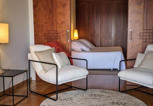 a small bedroom with two chairs and a bed at Hotel Sa Punta - Adults Only fr13 in Begur