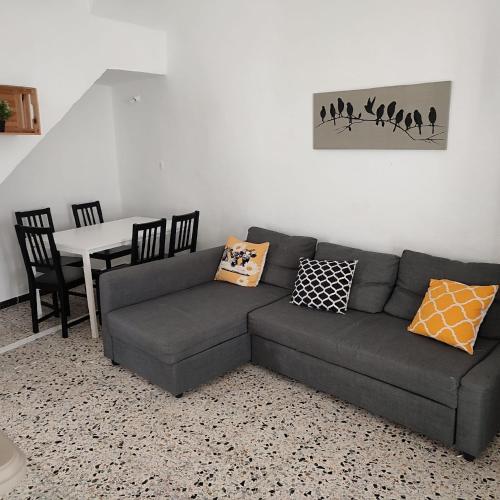 a living room with a couch and a table at Duplex en centro de Chipiona in Chipiona