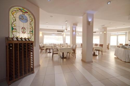 a dining room with tables and a stained glass window at Hotel Lebed in Ohrid