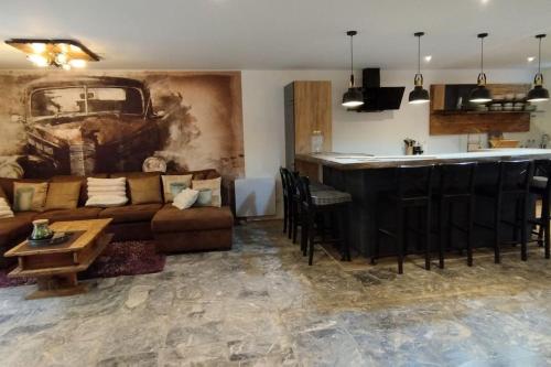 un salon avec un canapé et un bar dans l'établissement Bivouac & Sacs à dos - Loft classé, avec escape game sur demande, à Sixt-Fer-à-Cheval