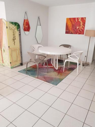 une salle à manger avec une table et des chaises sur un sol carrelé dans l'établissement Appartement avec jardin, à Eysines