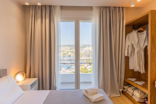 a bedroom with a bed and a window with a dresser at Iridium Old Town Luxury Suites in Kavala
