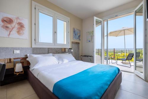 a bedroom with a large bed and a balcony at Fiore di Vendicari - Near the beaches of Calamosche and Vendicari in Noto
