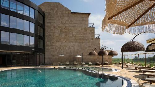 a hotel with a swimming pool in front of a building at Yarden Estate Boutique Hotel in Yesod Hamaala