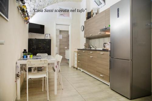 eine Küche mit einem Tisch und einem Kühlschrank in der Unterkunft Antico Lamione in Matera