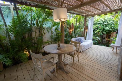 a patio with a table and chairs on a deck at Santa Fe Casas Hotel Trancoso in Trancoso