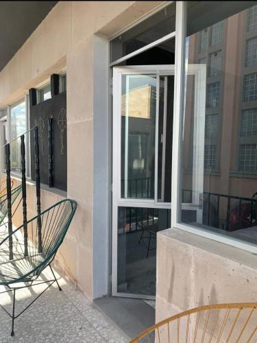 een glazen deur van een gebouw met een stoel bij Front vista in Aguascalientes