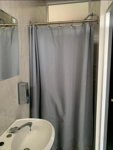 een badkamer met een douchegordijn en een wastafel bij Front vista in Aguascalientes