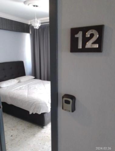 um quarto com uma cama e um relógio na parede em Front vista em Aguascalientes