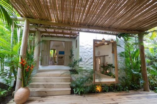 a house with a wooden walkway and a mirror at Santa Fe Casas Hotel Trancoso in Trancoso