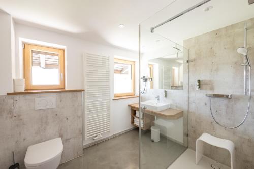 uma casa de banho com um chuveiro, um WC e um lavatório. em Haus Tannberg em Riezlern
