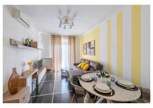 a living room with a table and a couch at Genova Holidays House Erma - Parcheggio Privato e Wi-Fi - AC in Genova