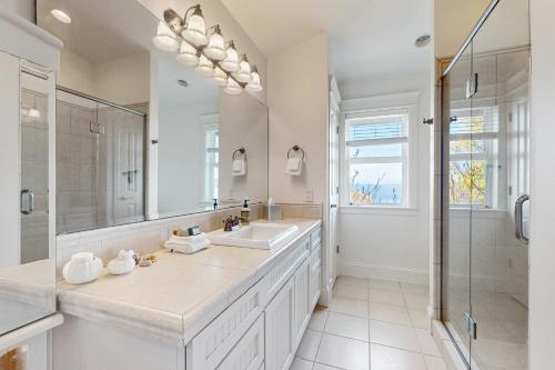 a white bathroom with a sink and a shower at Soundfront Serenity in Kingston