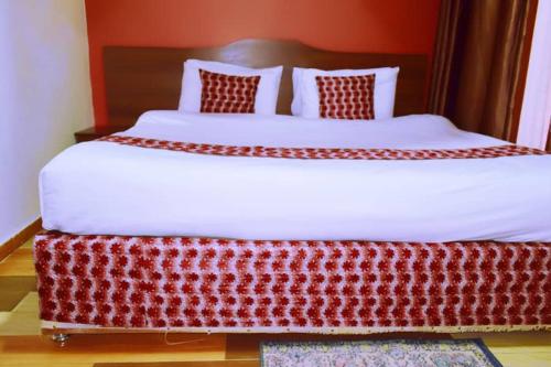 a bedroom with a large bed with a red headboard at Hôtel Saint Jean Leopold in Kigali