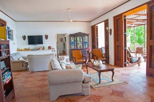 a living room with a couch and a table at Bliss By The Sea - Beach Front Villa with Private Pool in Treasure Beach