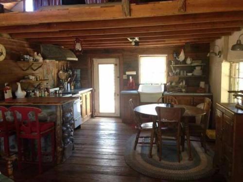 a kitchen and dining room with a table and chairs at Rancho Callado - Kumiai Cabin in Rinconada