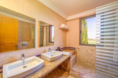 a bathroom with two sinks and a large window at Summer Villa Peaceful Golf Haven in Marrakech