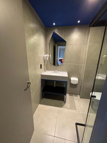 a bathroom with a sink and a mirror at Golden Tower Express Nações Unidas by Fênix Hotéis in Sao Paulo