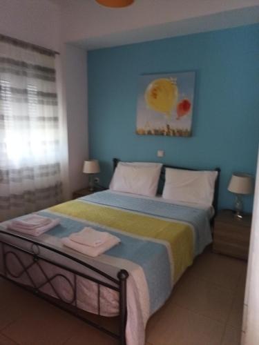 a bedroom with a bed with a blue wall at Endless Blue Apartments in Keratokampos