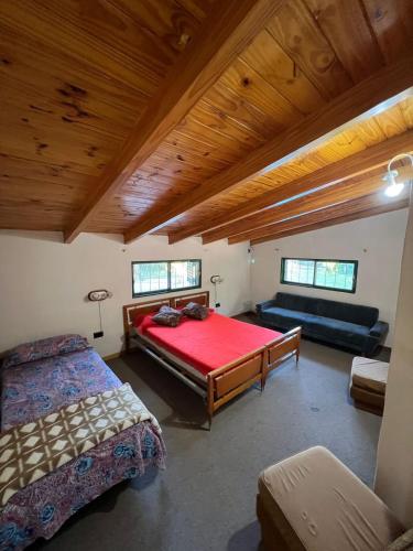 ein Schlafzimmer mit einem großen Bett und einer Couch in der Unterkunft Quinta Trento in Villa María