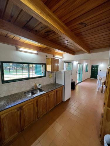 eine Küche mit Holzschränken und einem weißen Kühlschrank in der Unterkunft Quinta Trento in Villa María