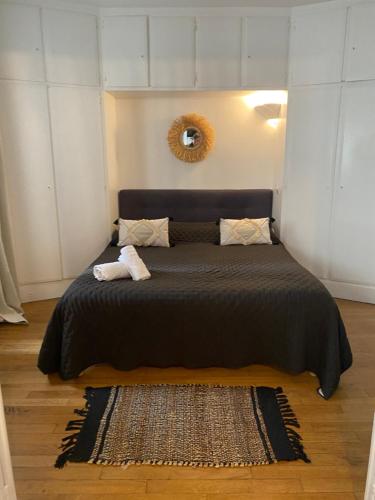 ein Schlafzimmer mit einem großen Bett mit einer schwarzen Decke in der Unterkunft Charmant 2 pièce 35m2 in Montrouge