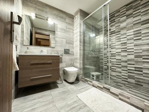 een badkamer met een douche, een wastafel en een toilet bij Appartement de luxe au Parc au centre pres de la plage in Mohammedia